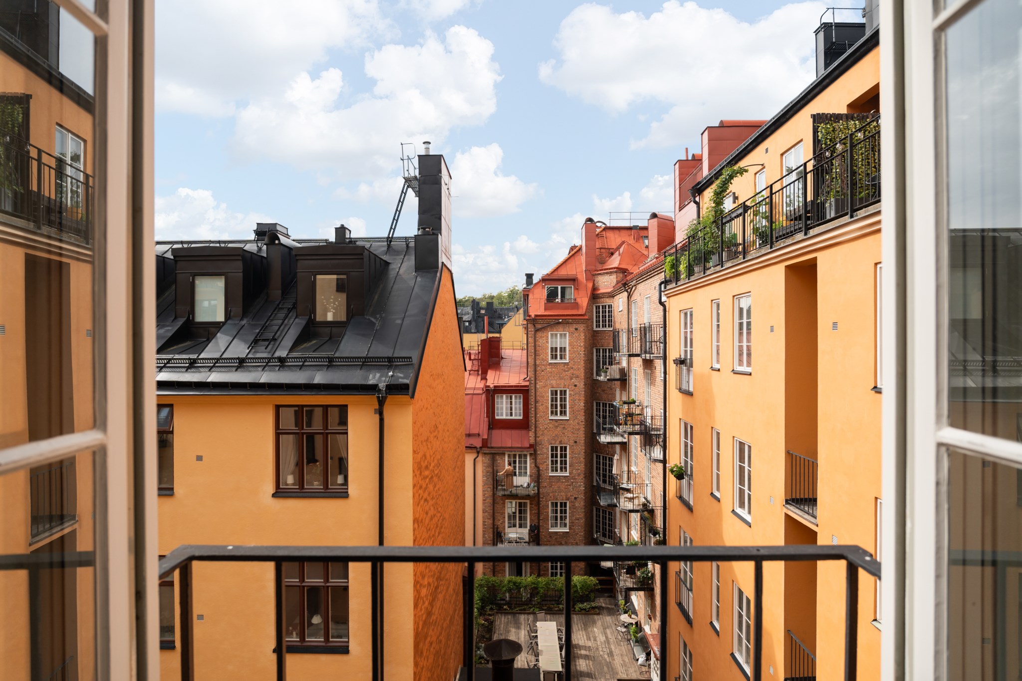 Fransk balkong med vacker vy över himmel, takåsar och fina sekelskifteshus Döbelnsgatan 57, 4 tr