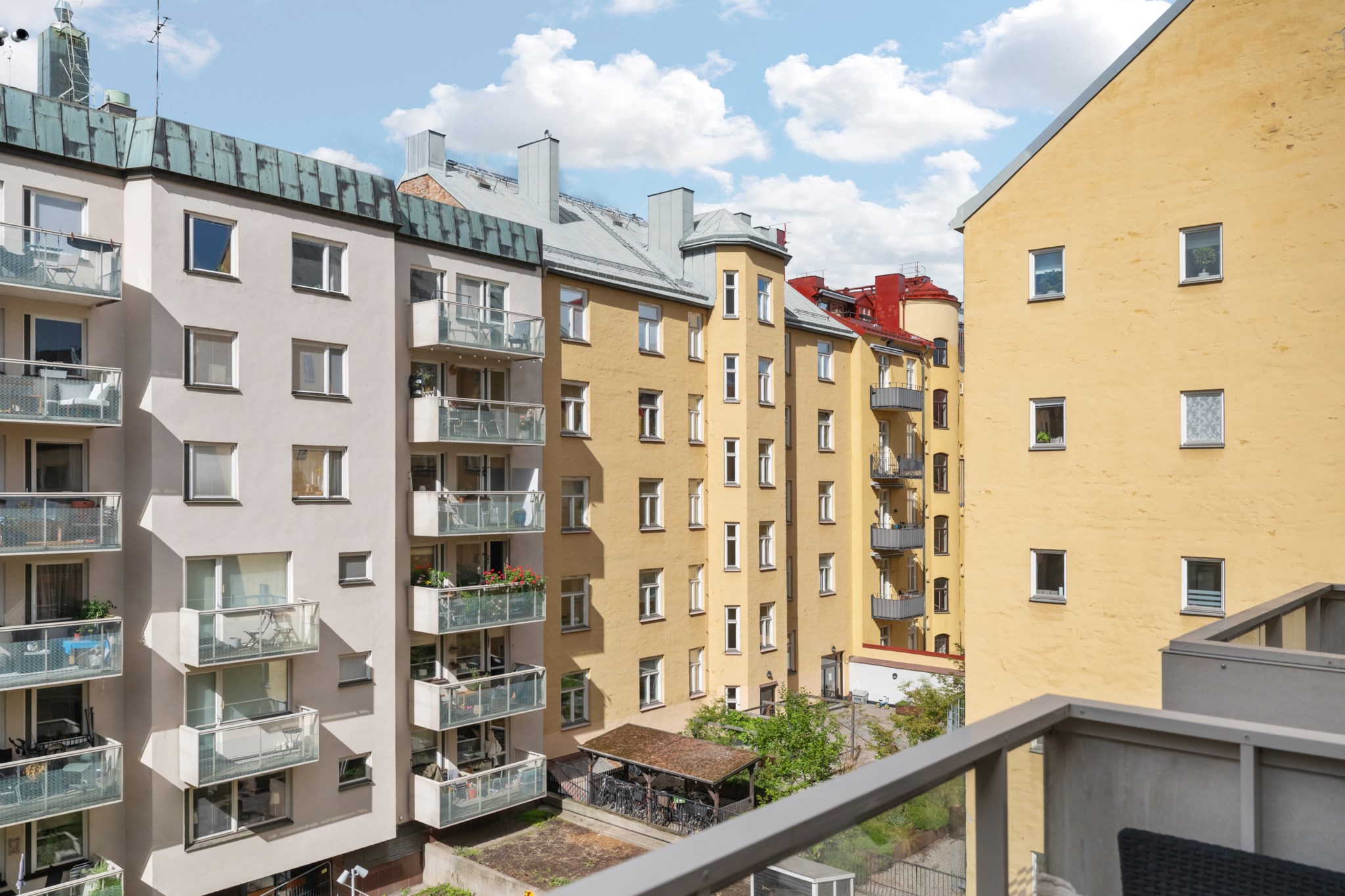 Fri vy över himmel, takåsar och grönskande gårdar. Birkagatan 16C, 4 tr ög