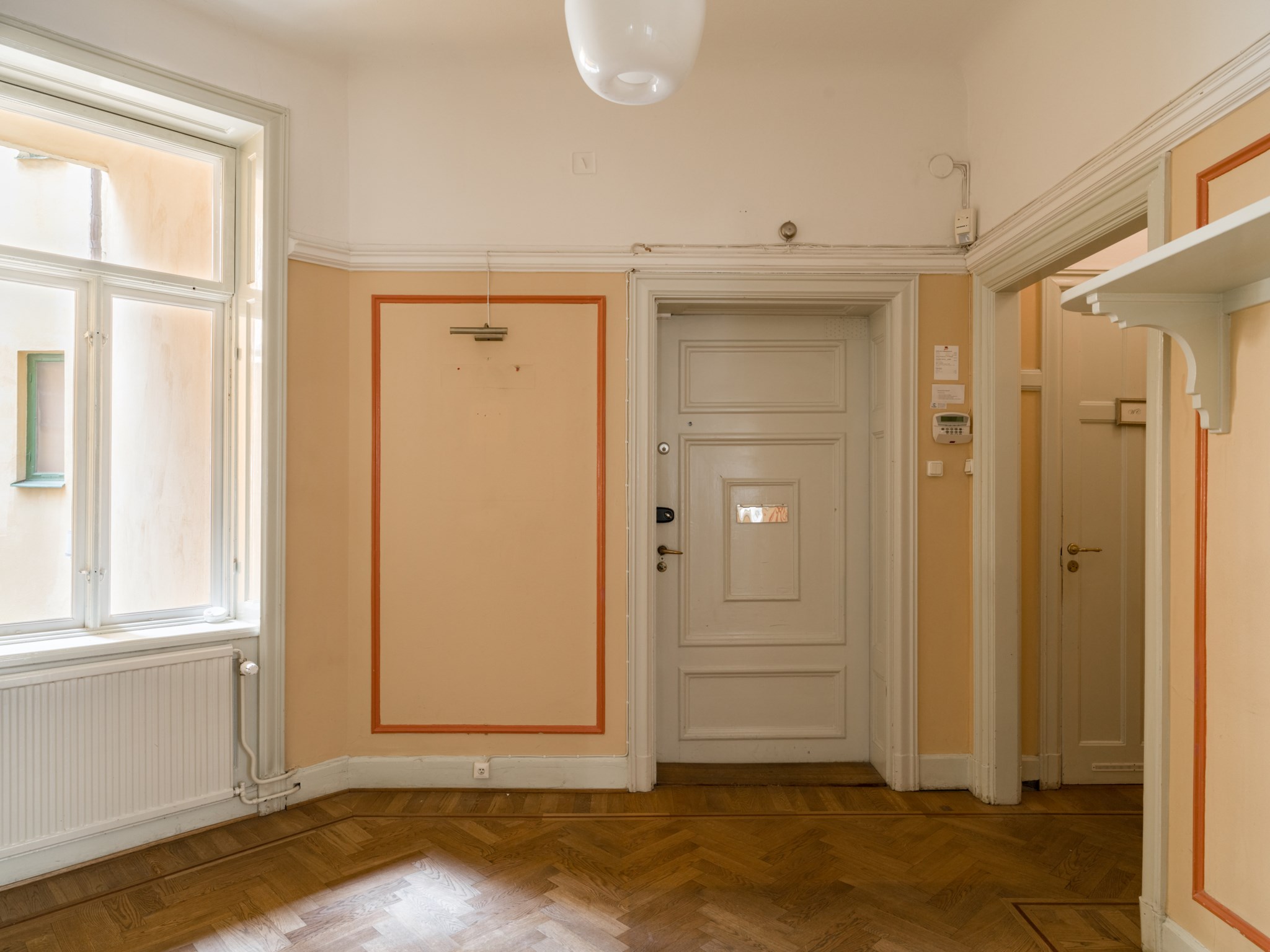 Vacker inbjudande hall med fönster, stavparkett och fina listverk i original Drottninggatan 85